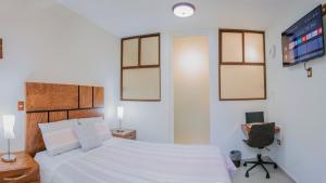 1 dormitorio con 1 cama, TV y silla en Casa Mariano en Morelia