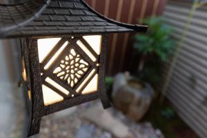 a black lantern hanging from the side of a porch at Kikokutei Bekkan in Kyoto