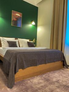 a bedroom with a large bed with a green wall at Hotel G.S. in Novokuznetsk