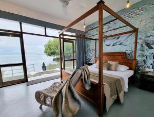 a bedroom with a canopy bed and a wall of windows at Kalpitiya Chalets by Thilanka in Kalpitiya