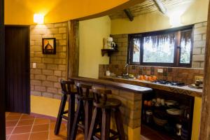 a kitchen with a counter and stools in a room at Cabaña Campestre Sol Muisca RNT85322 in Villa de Leyva