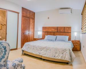 um quarto com uma cama grande e uma cadeira em Casa Mariano em Morelia