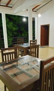 a dining room with a glass table and chairs at Yonara Green Rest in Habarana