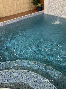 a swimming pool with a mosaic tile floor and a swimming pool at Oriental Nights Rest House in Al Wāşil