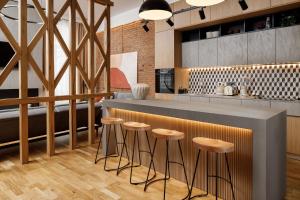 a kitchen with a counter and stools at a bar at Ka'yana Apartments - Restored Luxury in the Heart of the Old Town, near Black Church, Council Sq in Braşov +27 photos