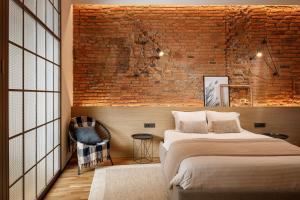 a bedroom with a bed and a brick wall at Ka'yana Apartments - Restored Luxury in the Heart of the Old Town, near Black Church, Council Sq in Braşov