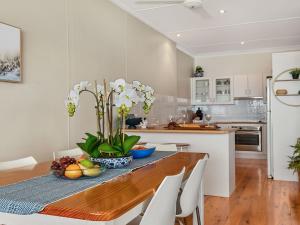 eine Küche mit einem Holztisch und weißen Geräten in der Unterkunft Ocean Blue Apartment Two in Currarong