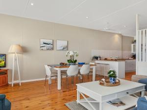 a living room with a table and a kitchen at Ocean Blue Apartment Two in Currarong +14 photos