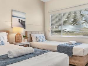 מיטה או מיטות בחדר ב-Ocean Blue Apartment Two