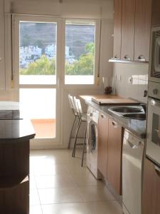cocina con fregadero y fogones horno superior en Comfortable and spacious apartment with nice views, en Benalmádena