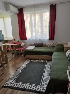 uma sala de estar com uma cama e uma mesa em 4 Seasons apartments, A2 em Plovdiv