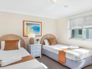 a bedroom with two beds and a window at Ocean Blue Apartment Five in Currarong