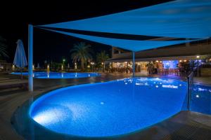 a swimming pool at night with a blue illumination at Isida Hotel Agia Marina in Agia Marina Nea Kydonias