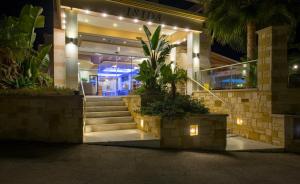 a building with stairs in front of a store at night at Isida Hotel Agia Marina in Agia Marina Nea Kydonias