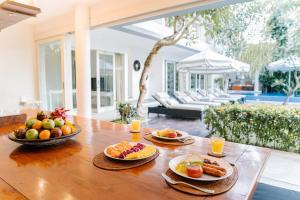 una mesa con platos de fruta encima en CassaMia Bali - Spacious Luxury 5 Bedroom Villa, 100m from Beach with Butler, en Jimbaran