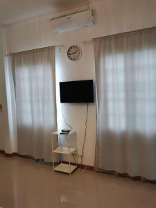 a room with a television and a clock on the wall at Baan Klang Khao Mountain Viewบ้านกลางเขา เมาเทนวิว in Ban Pang Asok