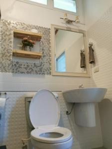 a bathroom with a toilet and a sink and a mirror at Baan Klang Khao Mountain Viewบ้านกลางเขา เมาเทนวิว in Ban Pang Asok