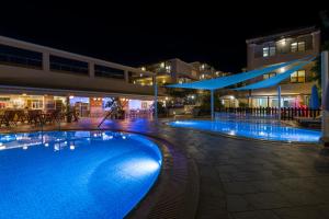 a swimming pool in front of a building at night at Isida Hotel Agia Marina in Agia Marina Nea Kydonias
