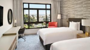 una camera d'albergo con due letti, una scrivania e una finestra di InterContinental Jordan, an IHG Hotel ad Amman