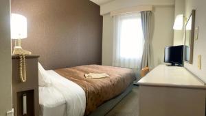 a hotel room with a bed and a television at Yono Daiichi Hotel in Saitama
