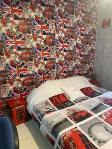 1 cama en un dormitorio con una pared cubierta de banderas británicas en Les 4 M en Gercourt-et-Drillancourt