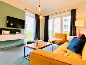 een woonkamer met een gele bank en een tafel bij Apartment Waterkamp, 26316 Dangast in Dangast