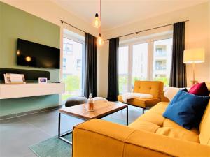 a living room with a yellow couch and a table at Apartment Waterkamp, 26316 Dangast in Dangast