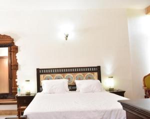 - une chambre avec un grand lit blanc et 2 tables de chevet dans l'établissement Osian The Desert Boutique Hotel, à Khāra
