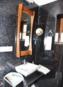 La salle de bains est pourvue d'un lavabo et d'un miroir. dans l'établissement Osian The Desert Boutique Hotel, à Khāra