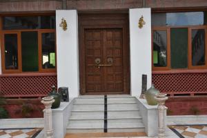 - une porte en bois sur une maison avec des escaliers dans l'établissement Osian The Desert Boutique Hotel, à Khāra