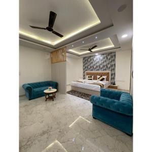 1 dormitorio con 1 cama y 2 sofás azules en Maps Inn, en Ghaziabad