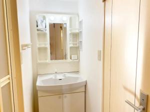 uma casa de banho branca com um lavatório e um espelho em Tsunoya em Tóquio
