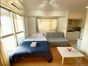 um quarto com uma cama, um sofá e uma mesa em Tsunoya em Tóquio