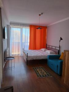a bedroom with a bed and a blue couch at Twins studio N339 in Gudauri