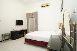 a bedroom with a bed and a tv in it at OYO 93411 Syariah Hotel Tomborang in Karema