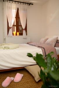 代斯波托瓦茨的住宿－Lek za dušu，卧室内的两张床,地板上配有粉红色的拖鞋