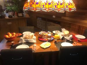 mesa de comedor con lámpara de araña y comida en BlackPearl Boat&Breakfast, en Terneuzen