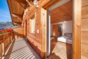 uma casa de madeira com uma varanda com uma cama em Unterstuanerhof Plattnerblick em Stulles