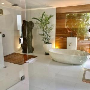 a bathroom with a large tub and a plant at Villa Madu Canggu in Canggu
