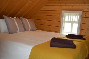 a bedroom with a large white bed with a window at Lainela Holiday Park in Käsmu