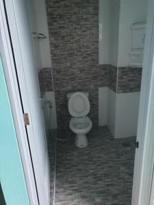 La salle de bains est pourvue de toilettes blanches. dans l'établissement Lert Sri Hotel, à U Thong