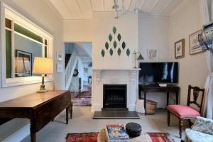 a living room with a fireplace and a tv at Timeless 2BR Grey Lynn Cottage - Fibre - WiFi in Auckland