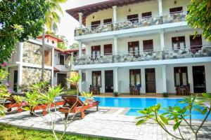ヒッカドゥワにあるVilla De White Samburのホテルとプールの景色を望めます。
