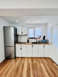 a kitchen with white cabinets and a stainless steel refrigerator at Master Adventure Guest House in Vadul lui Carol II