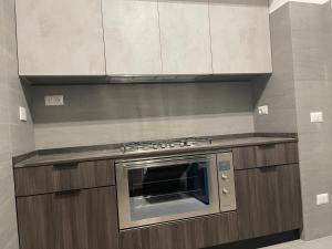 una cocina con horno de acero inoxidable y armarios en ATTICO FRONTE MARE, en Lido di Ostia 10 fotos más