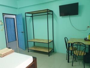 U ThongにあるLert Sri Hotelのベッド、テーブル、テレビが備わる客室です。