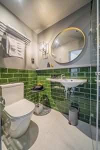 a bathroom with a toilet and a sink and a mirror at Leo Boutique Rooms - Adults Only in Budapest