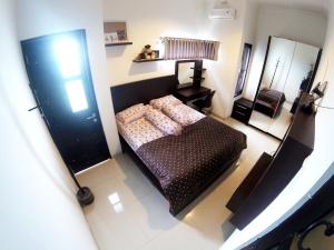 een kleine slaapkamer met een bed en een spiegel bij Godean Living Homestay Jogja Family only in Ngabean