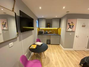 a room with a table and chairs and a kitchen at Modern Luxury 1 bed apartment with parking near Stansted Airport in Stansted Mountfitchet