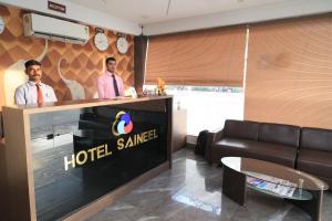 two men are standing at a hotel samheard reception desk at Hotel Sai Neel in Surat